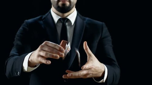 Close-up of a Skilled Magician in a Black Suit Performing Card Trick. Throwing and Catching Cards D