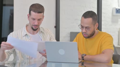Two Colleagues Discussing Data with Laptop