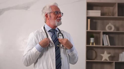 Médico senior maduro con gafas y uniforme médico en el hospital o en el consultorio del médico general