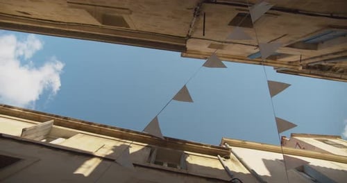 Low angle dreamlike street view of Montpellier France looking up at strings of bunting and blue skie