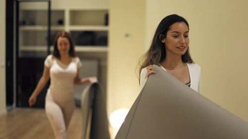 Group of Women Preparing for Yoga Class in Fitness Studio