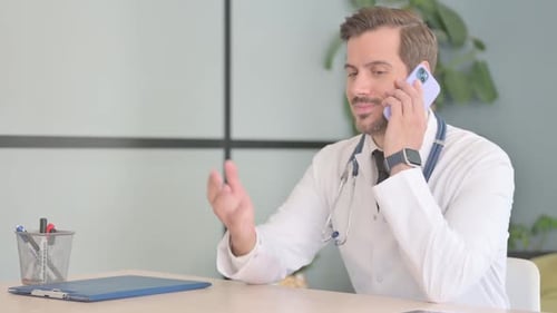 Male Doctor Talking on Phone in Clinic