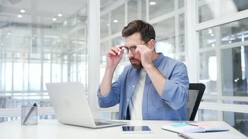 Man Working on Laptop in Bright Office