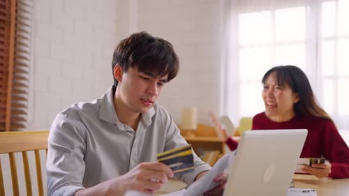 Asian young depressed couple having argument while checking money debt.