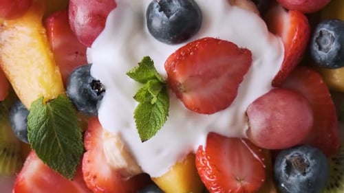 Healthy Fresh Fruit Salad with Yogurt in a Bowl on Pink Background Top View Summer Healthy Food for