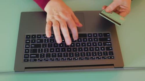 A Female Hand is Captured Holding a Credit Card in the Process of Making an Ecommerce