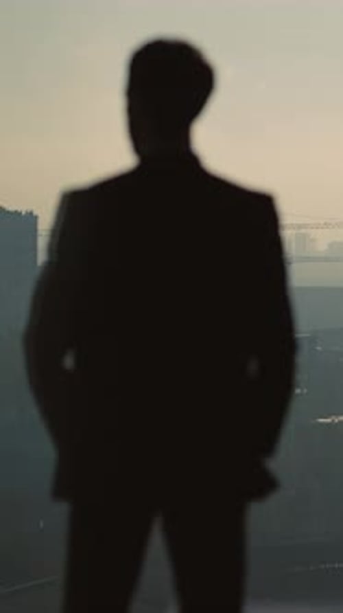 Silhouette of Man in Suit Contemplates City View