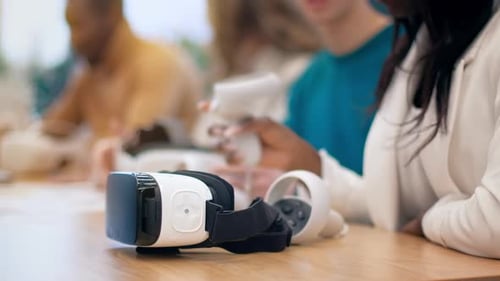 Close view of VR goggles at business conference in an office. Multiracial group of people using VR g