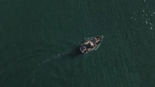 Luftaufnahme eines Fischerboots, das an flachem Wasser vorbeifährt