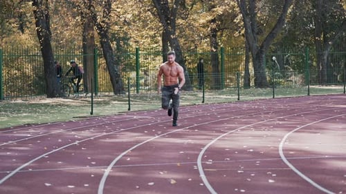 Fitness young man running at sports stadium.