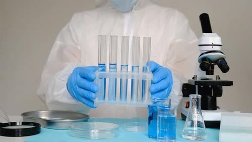 Lab Worker Analyzing Test Tubes in Laboratory