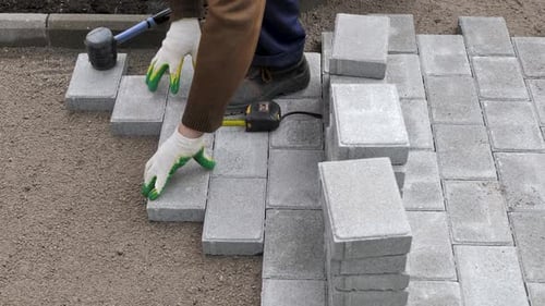 Adult Installing Brick Pavers for Construction
