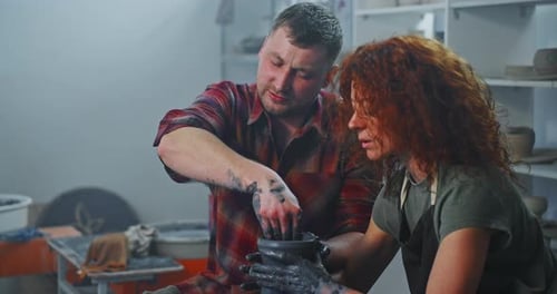 Couple Making Clay Pot Together on Potter's Wheel