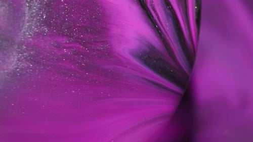 Swirling purple and black paint with shimmering glitter