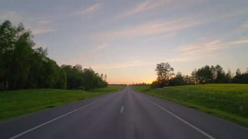 Driving along a country road at sunset