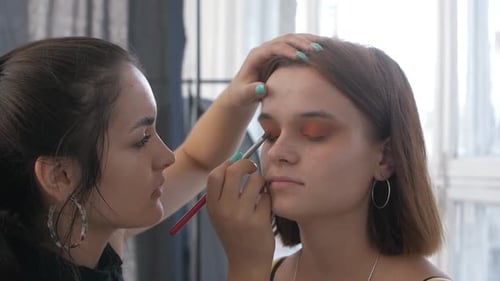 Maskenbildner Makeup auf das Gesicht des Models auftragen Nahaufnahme