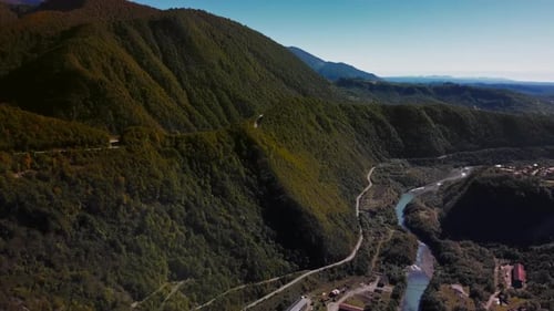 Aerial View of Majestic Mountains with Meandering Rivers and Rolling Hills in Lush Shades of Green