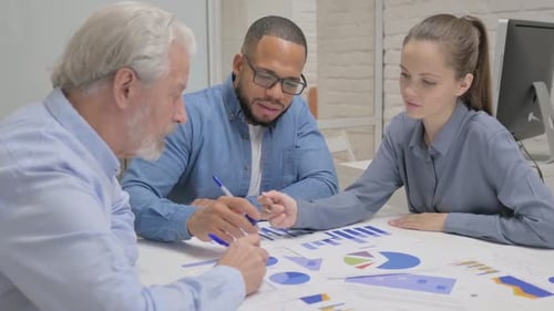 Office Team Discussing Charts and Graphs