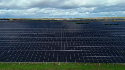 Aerial view of solar panel farm with cloudy sky