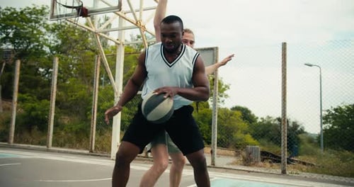 Dynamisches Basketballspiel Einer der Spieler umgeht den anderen und erzielt ein brillantes Torspiel bei
