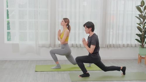 Joven hombre y mujer asiáticos practicando yoga y estirando los músculos de las manos y la espalda para la salud juntos.