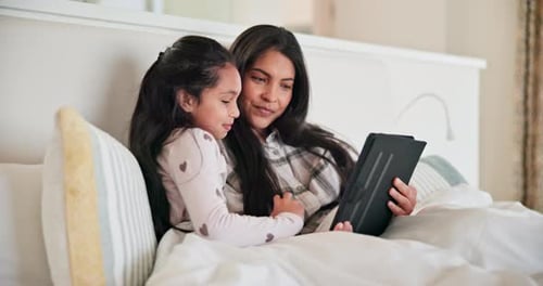 Mother and Child Smiling with Tablet in Bed