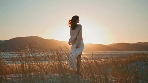 Woman in Dress Reaches for Sunset on Beach