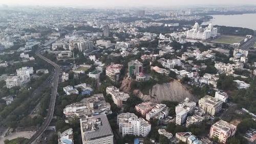 Wide cinematic aerial of Hyderabad highlighting urban density, mixed architecture, and green