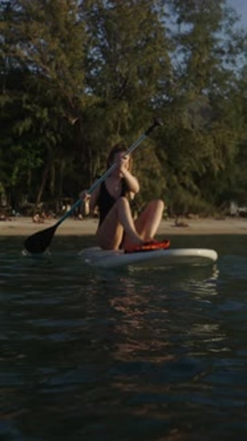 Caucasian Smiling Girl Paddle Surfing on a Beach in Thailand