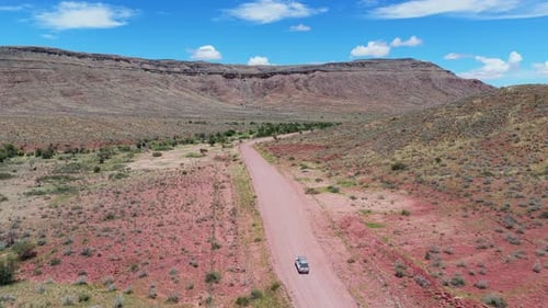 White Suv Driving on Desert Gravel Road in Middle of Rocky Canyon in Namibia Exploring Stunning
