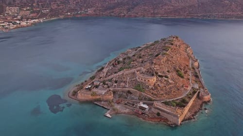 Aerial view of a historic fortress island near the coast at sunset