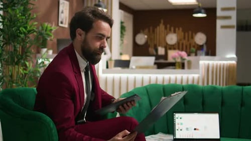 Man in Suit Uses Tablet in Hotel Lobby
