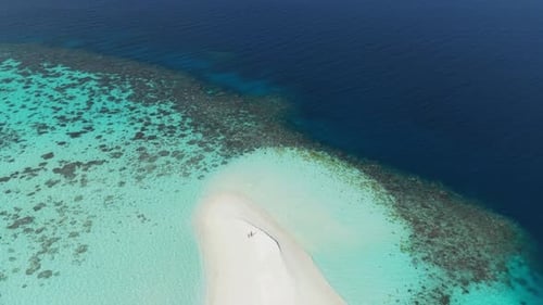 Aerial View of a Serene Island in the Maldives Featuring White Sand Beach and Coral Reef