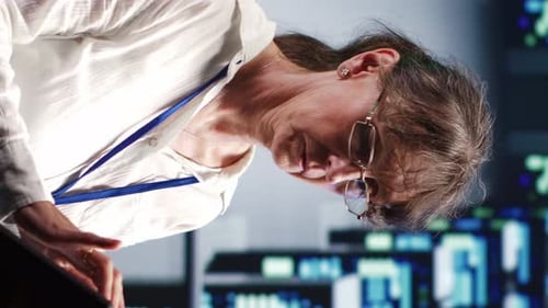 Woman Using Touchscreen in Dimly Lit Workplace