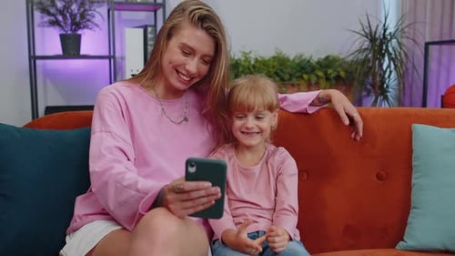 Woman and Child Enjoying Phone Together Indoors