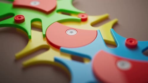 Looping 3D animation multi-colored plastic toy gears.
