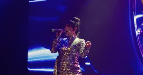 Confident Woman Singing on a Stage at Night
