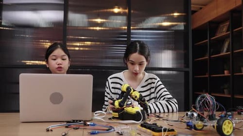 Teen Girl Builds Robot with Child in Modern Home