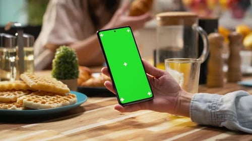 Vertical Green Screen Smartphone Held By Mom Serving Breakfast with Daughter