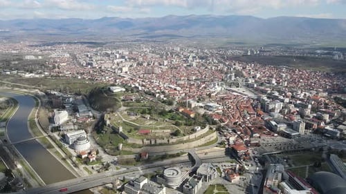 Drone view of the city of Skopje crossing the Vardar River, stone castle in the city center