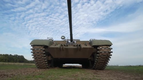 Stationary Military Tank on Grassy Field Under Cloudy Sky