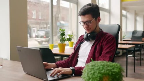 Camera Flies Around Developer Writing Program Code on Computer Display Alone in Office Freelancer