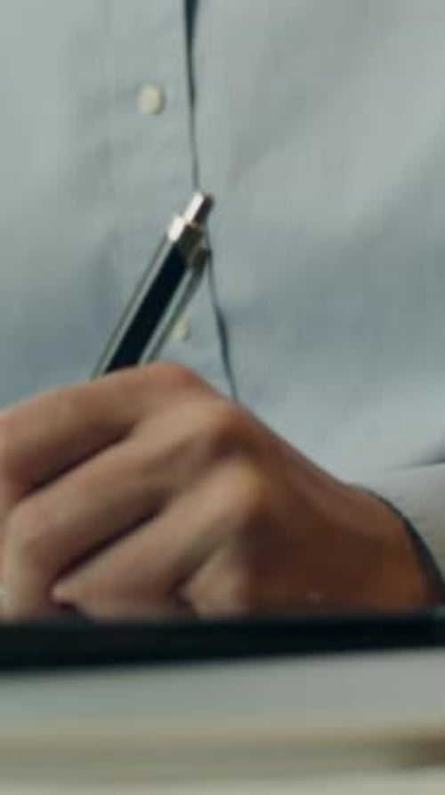 Hand Writing in Notebook With Pen at Desk