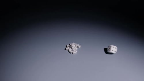 White Dice Rolling and Piling on Gray Surface