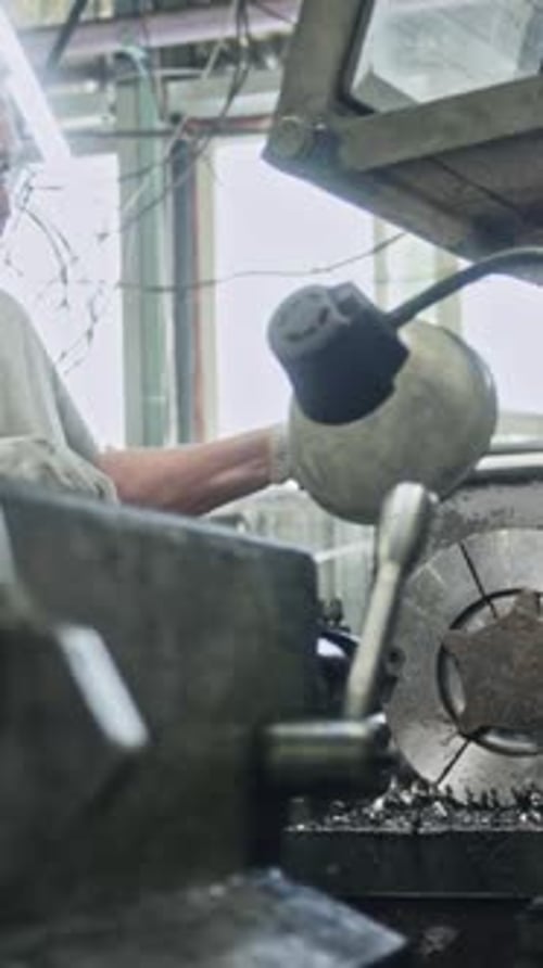Expert machinist using lathe in industrial workshop