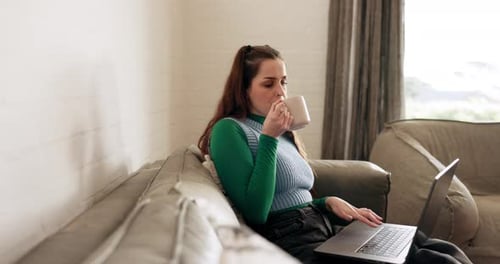 Woman Works on Laptop While Drinking Coffee at Home
