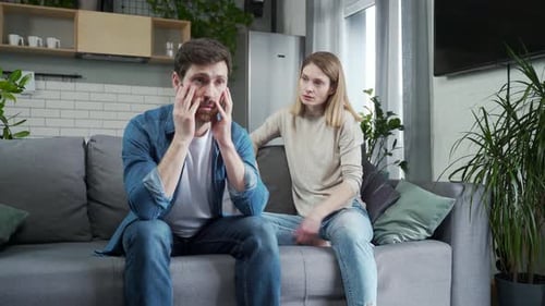 Upset Couple Arguing on Sofa in Living Room
