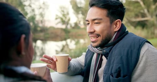 Young Adults Conversing Outdoors with Coffee