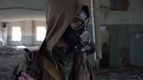 Ein Mann Stalker in einer Gasmaske steht in einem verlassenen Gebäude Nahaufnahme