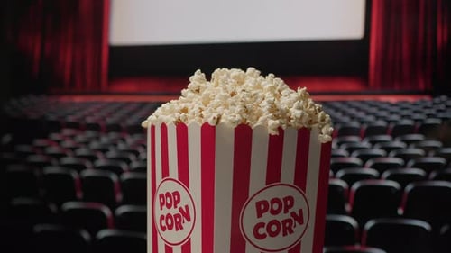 Rotating Popcorn Basket with Cinema Screen in Background